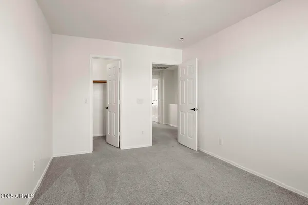 an empty room with closet and a bathroom