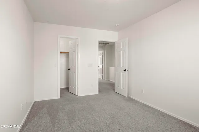 an empty room with closet and a bathroom