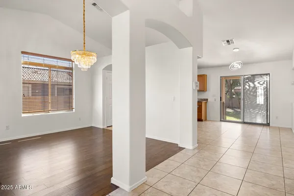 a view of an empty room with wooden floor and stairs