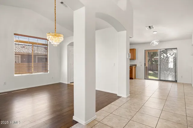a view of an empty room with wooden floor and stairs