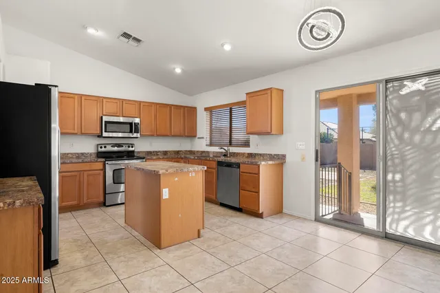 a kitchen with stainless steel appliances granite countertop a refrigerator stove and a sink