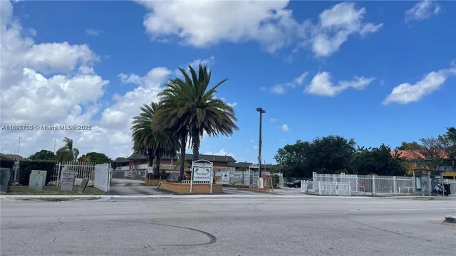 a row of palm trees in front of a house