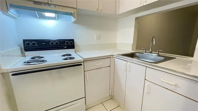 a kitchen with white cabinets and white appliances