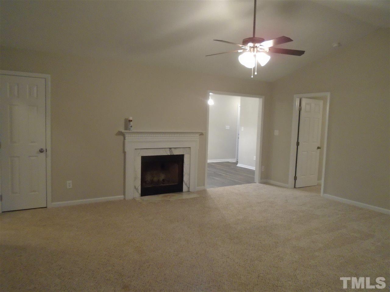 4004 Rockside Hills Drive Raleigh, NC 27603 - Photo 2 of 14 a view of a livingroom with a fireplace a chandelier and a window