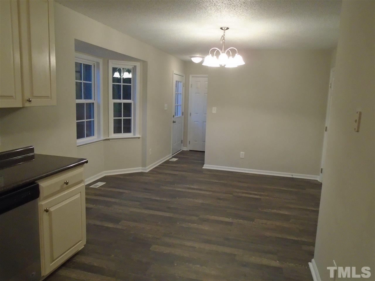 4004 Rockside Hills Drive Raleigh, NC 27603 - Photo 8 of 14 an empty room with wooden floor and cabinets