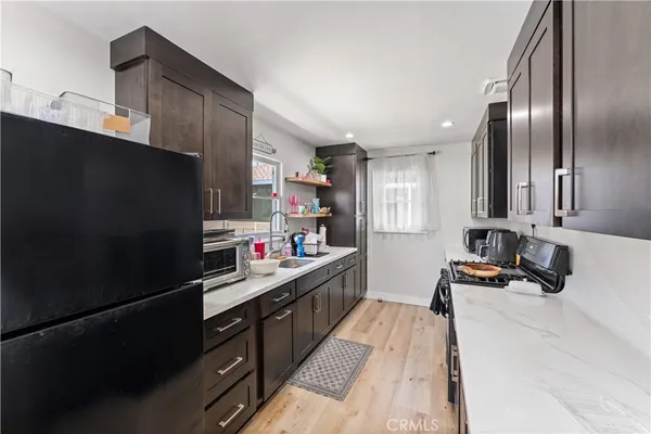 a kitchen with stainless steel appliances a sink stove refrigerator and cabinets