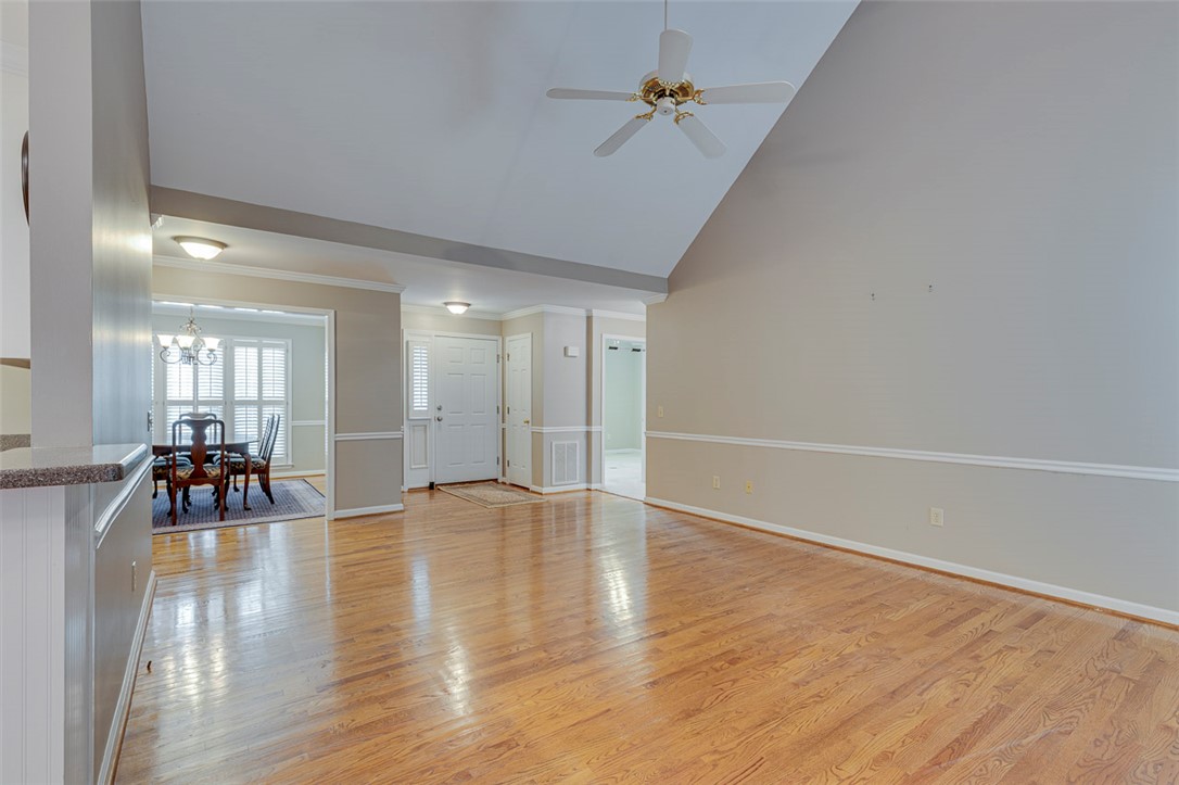 302 Wild Rice Drive Simpsonville, SC 29681 - Photo 8 of 44 Polished hardwood flooring runs through this airy living area featuring a vaulted ceiling.