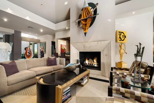 a living room with furniture kitchen view and a fireplace