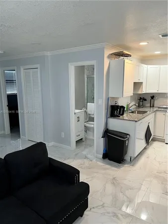 a living room with stainless steel appliances kitchen island granite countertop a stove a sink and a refrigerator