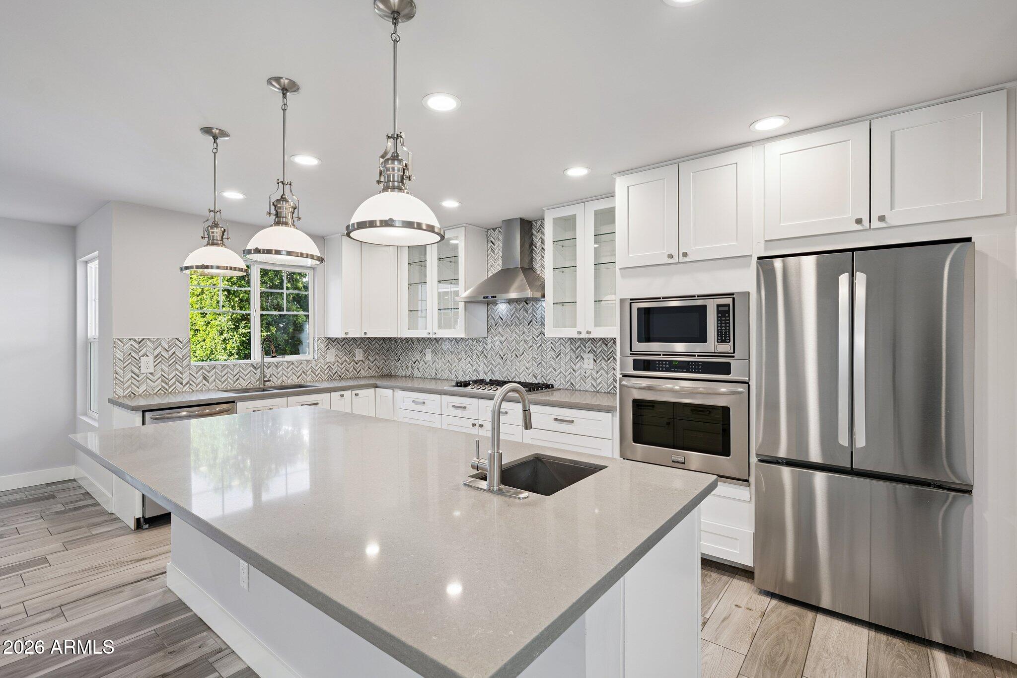 4232 North 19th Place Phoenix, AZ 85016 - Photo 10 of 39 a kitchen with stainless steel appliances a refrigerator a sink a stove a microwave a center island and cabinets