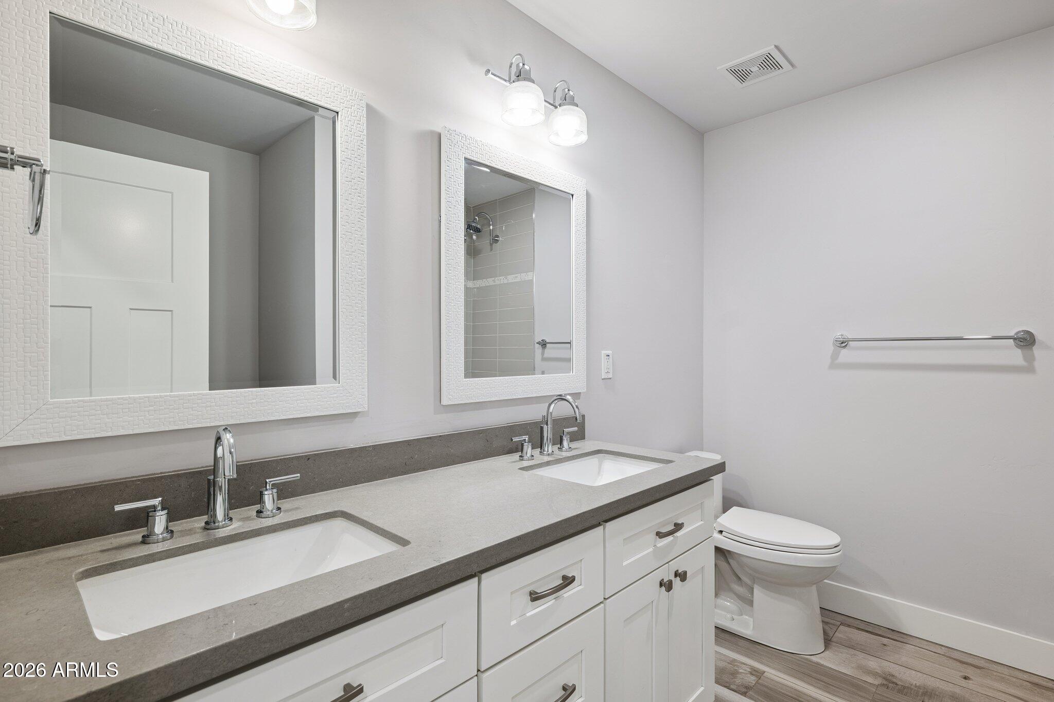 4232 North 19th Place Phoenix, AZ 85016 - Photo 26 of 39 a bathroom with a granite countertop sink a toilet and a mirror