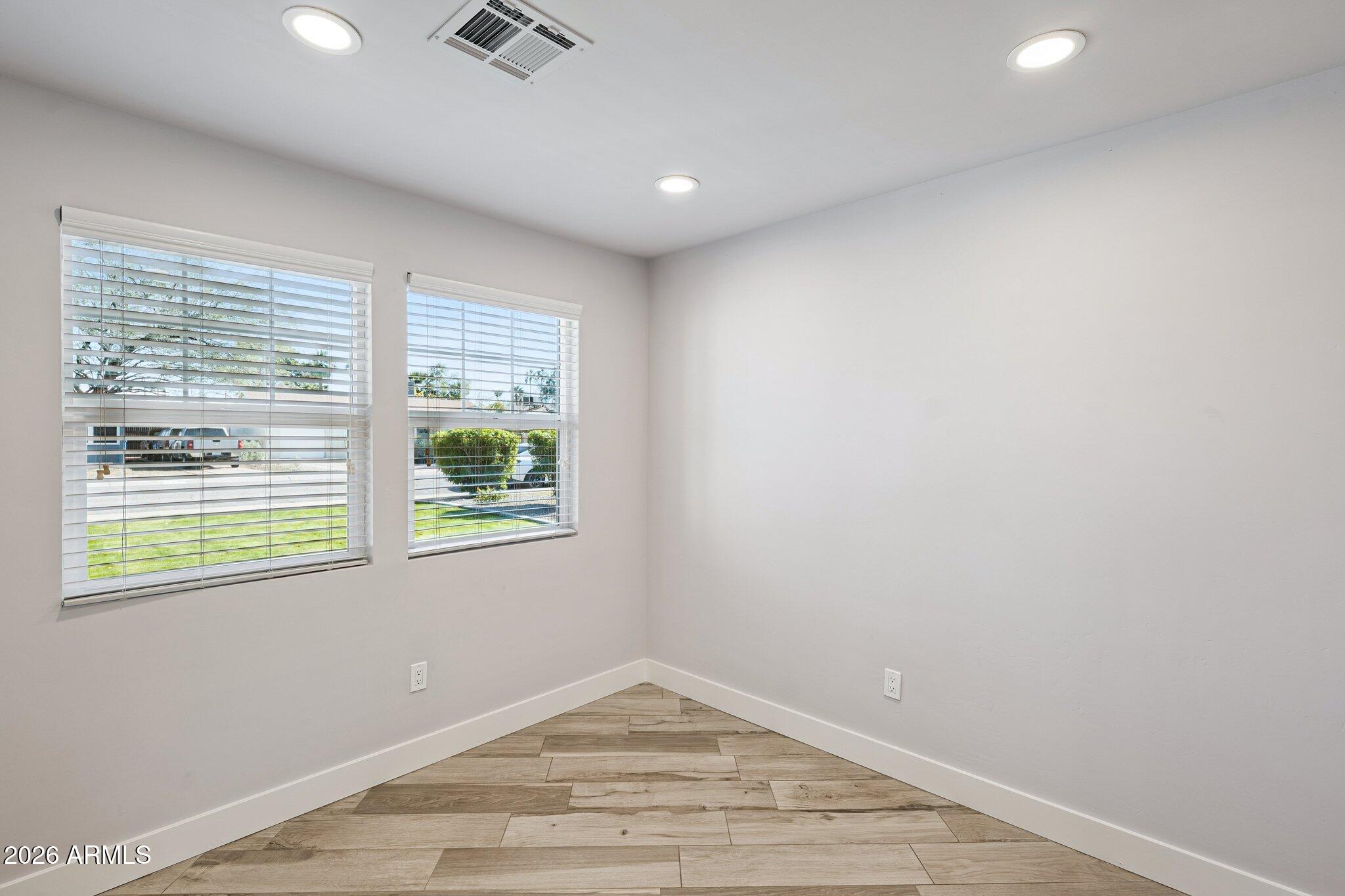 4232 North 19th Place Phoenix, AZ 85016 - Photo 6 of 39 an empty room with wooden floor and windows