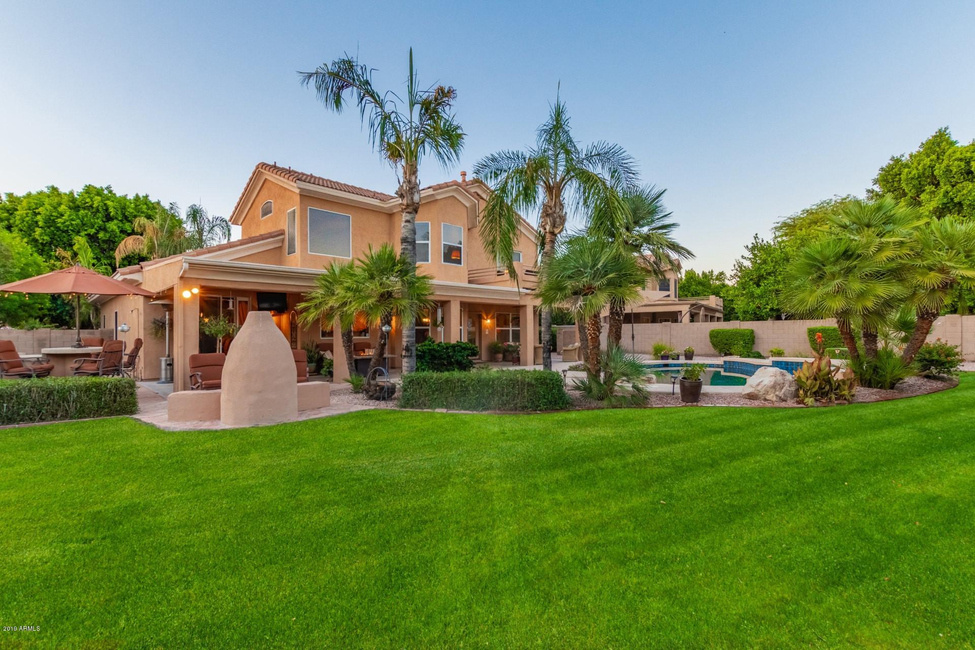 6015 East Phelps Road Scottsdale, AZ 85254 - Photo 1 of 72 a front view of a house with a garden and trees