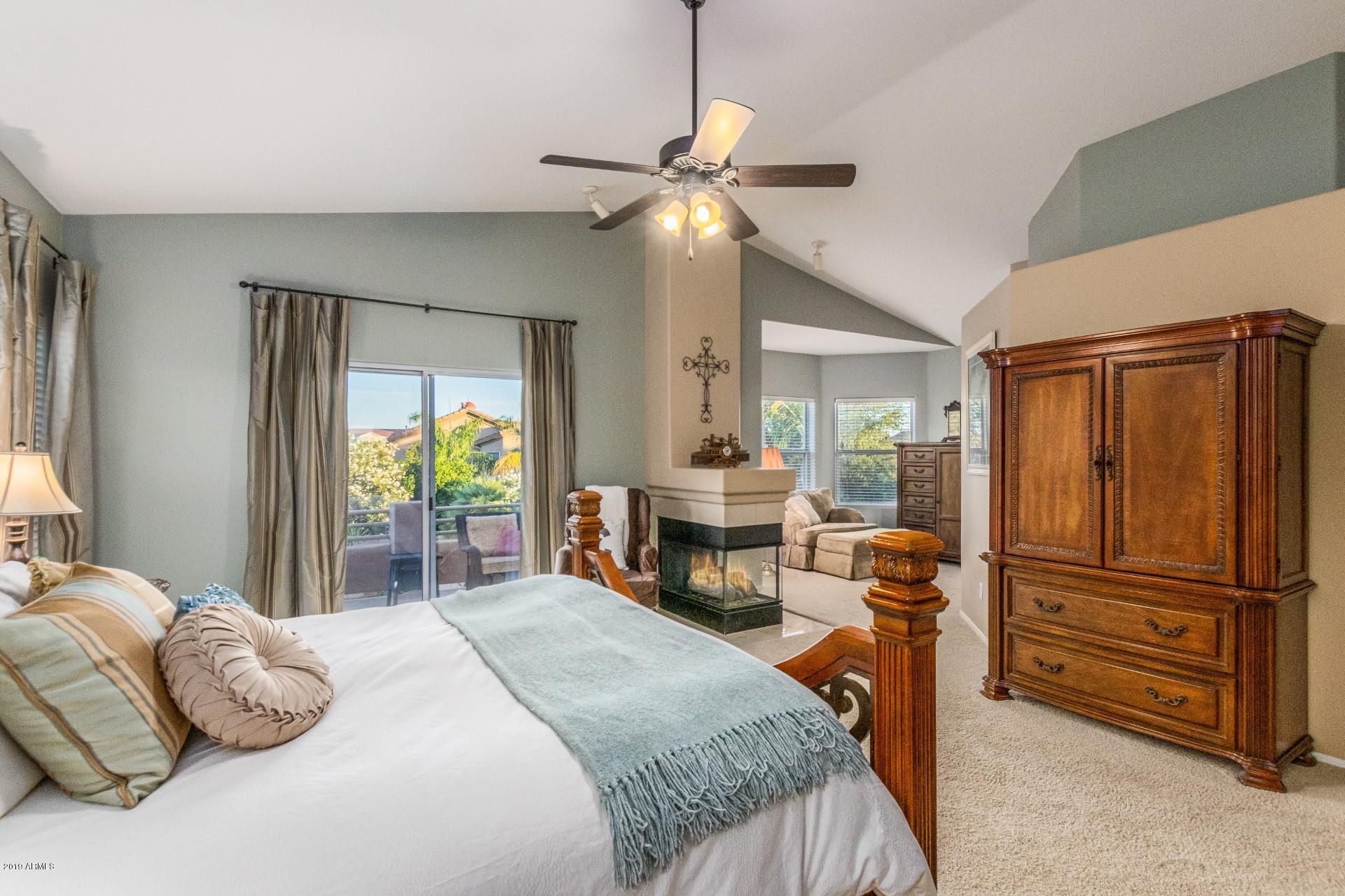 6015 East Phelps Road Scottsdale, AZ 85254 - Photo 27 of 72 a bedroom with a bed and a chandelier