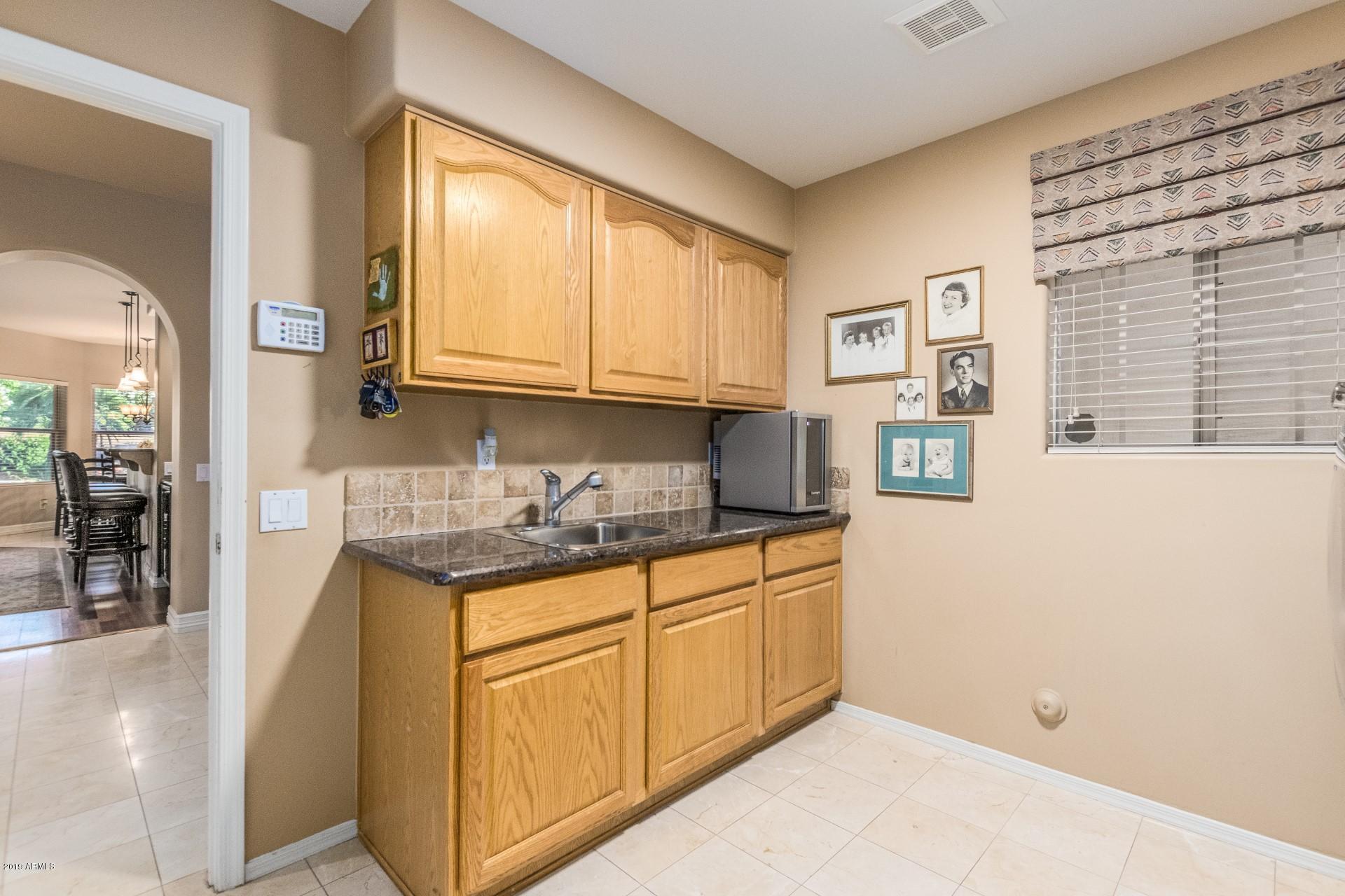 6015 East Phelps Road Scottsdale, AZ 85254 - Photo 44 of 72 a kitchen with granite countertop a sink and cabinets