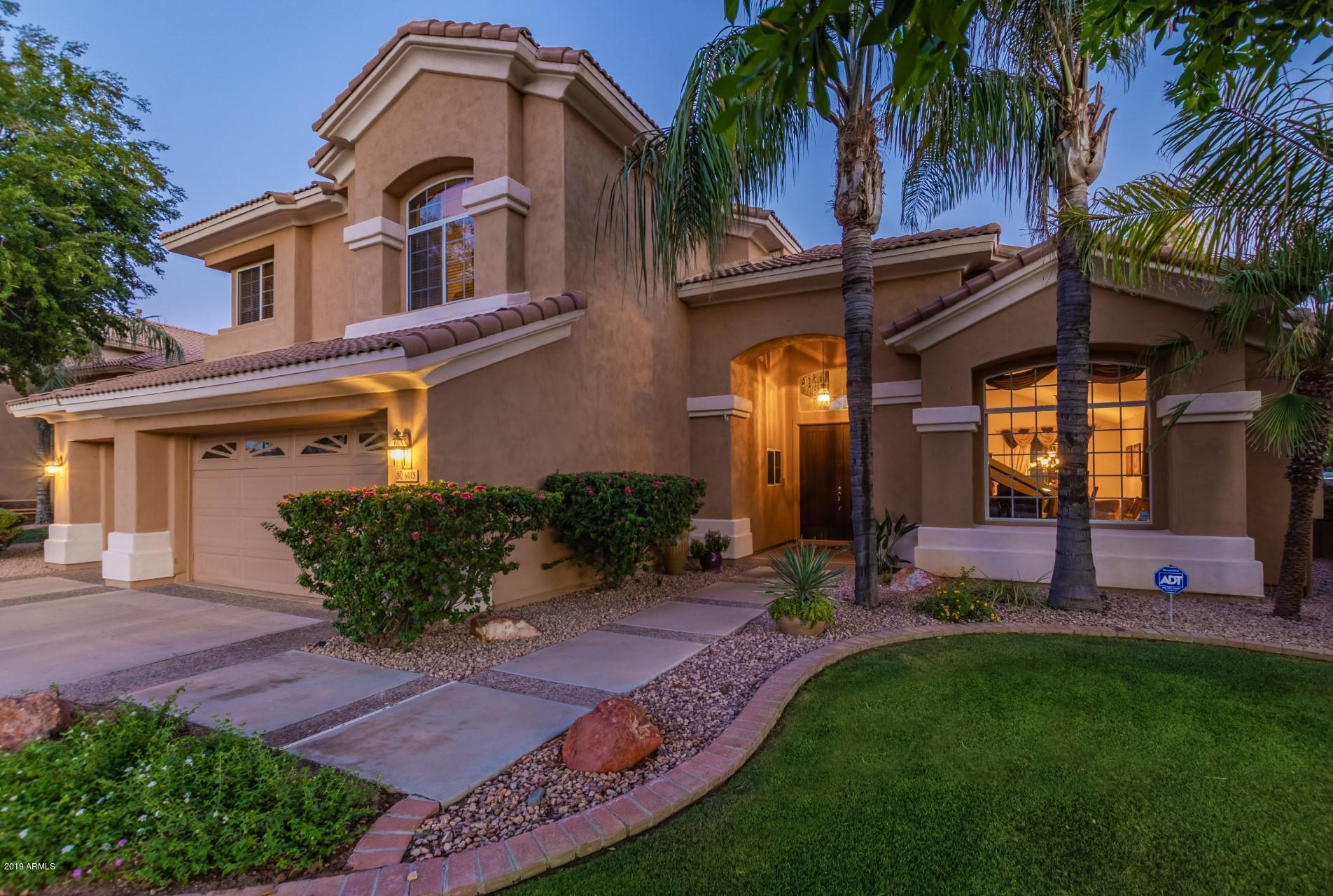 6015 East Phelps Road Scottsdale, AZ 85254 - Photo 54 of 72 a front view of a house with a yard and potted plants