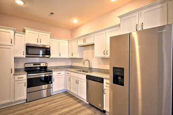 a kitchen with granite countertop cabinets stainless steel appliances and a counter space