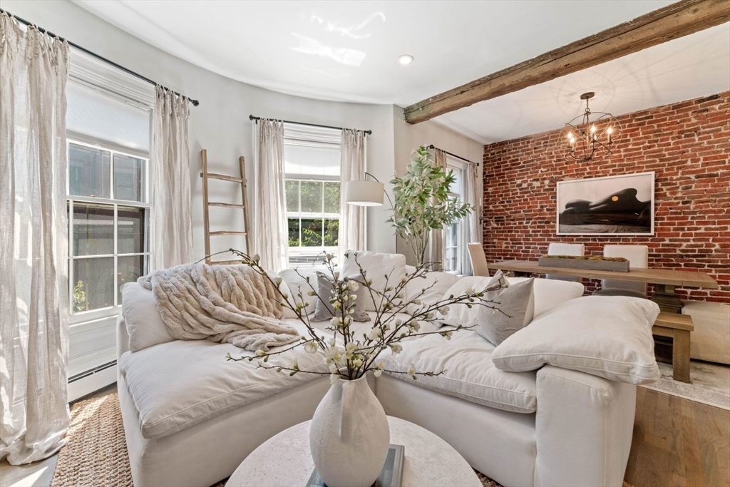 91 Waltham Street, Unit 4 Boston, MA 02118 - Photo 1 of 26 a living room with furniture a large window and a flat screen tv