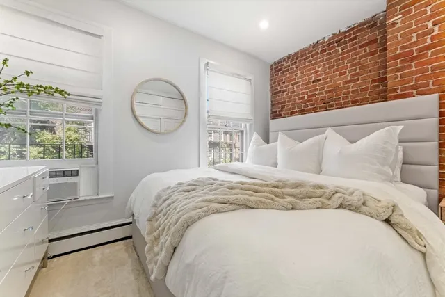 a bed sitting in a bedroom next to a window