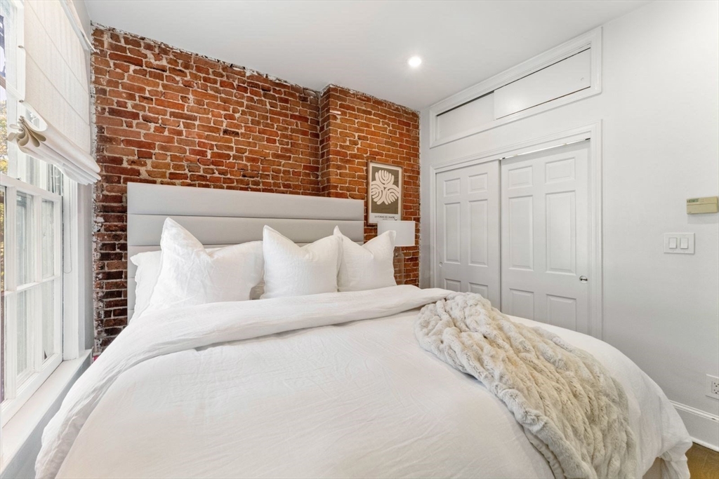 91 Waltham Street, Unit 4 Boston, MA 02118 - Photo 17 of 26 a large bed sitting in a bedroom and a larger closet