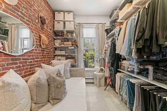 a view of walk in closet with clothes and shoes