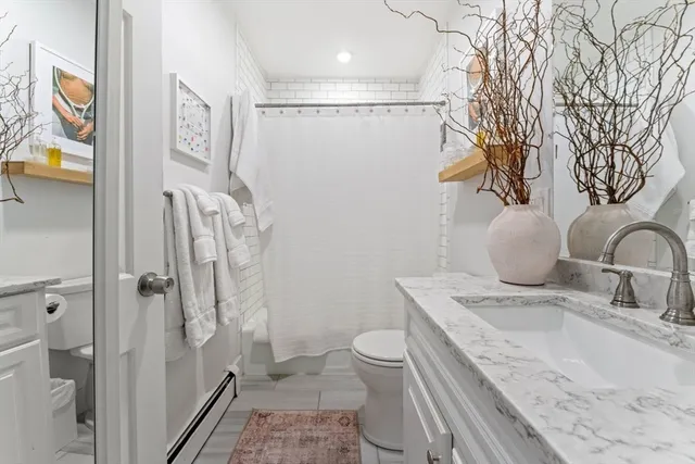 a bathroom with a granite countertop sink a toilet and shower