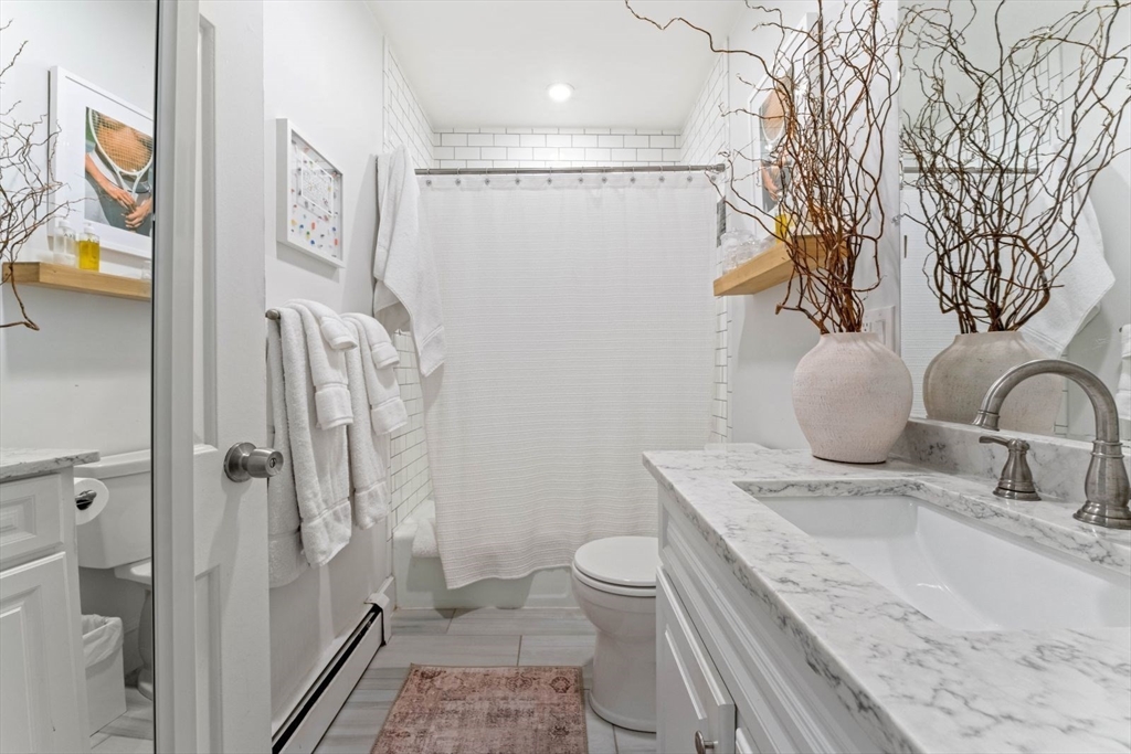 91 Waltham Street, Unit 4 Boston, MA 02118 - Photo 20 of 26 a bathroom with a granite countertop sink a toilet and shower