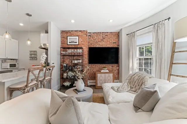 a living room with furniture a flat screen tv and a view of kitchen
