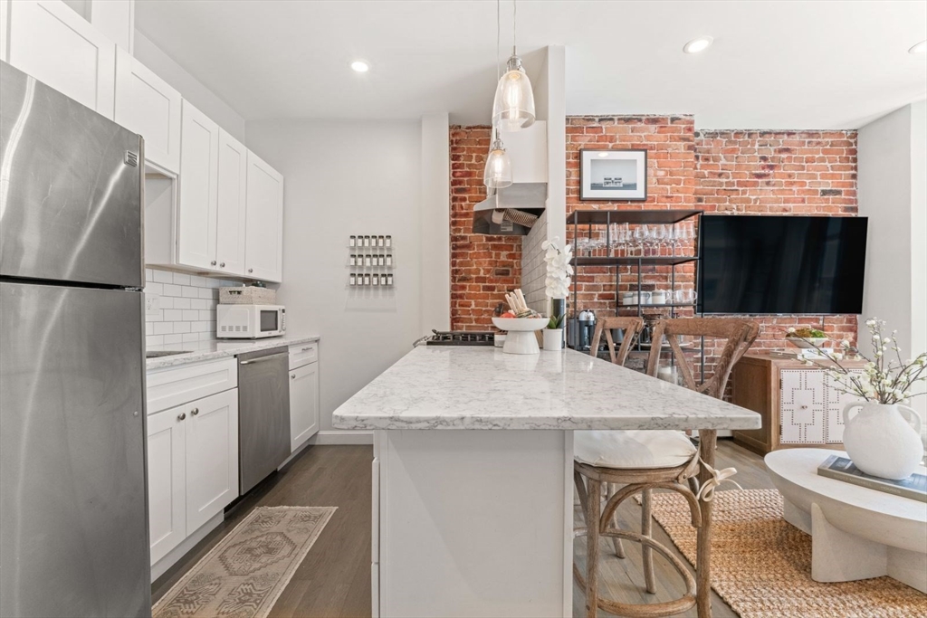 91 Waltham Street, Unit 4 Boston, MA 02118 - Photo 9 of 26 a kitchen with stainless steel appliances a stove refrigerator sink and cabinets