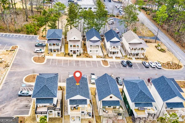 an aerial view of a house with swimming pool and large trees