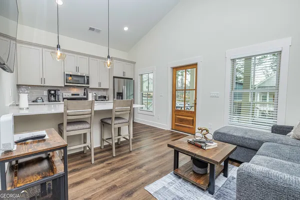 a living room with furniture flat screen tv and kitchen view