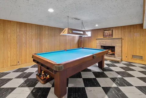 a room with pool table and a fireplace