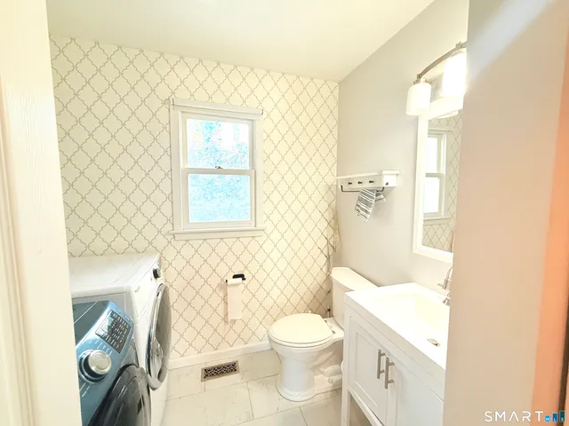 a bathroom with a toilet sink and a mirror