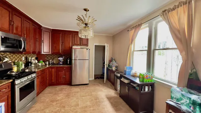 a kitchen with stainless steel appliances granite countertop a refrigerator a stove top oven a sink and dishwasher