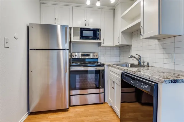 a kitchen with stainless steel appliances granite countertop a refrigerator stove a sink and a microwave