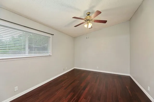 a view of a room with wooden floor and a fan
