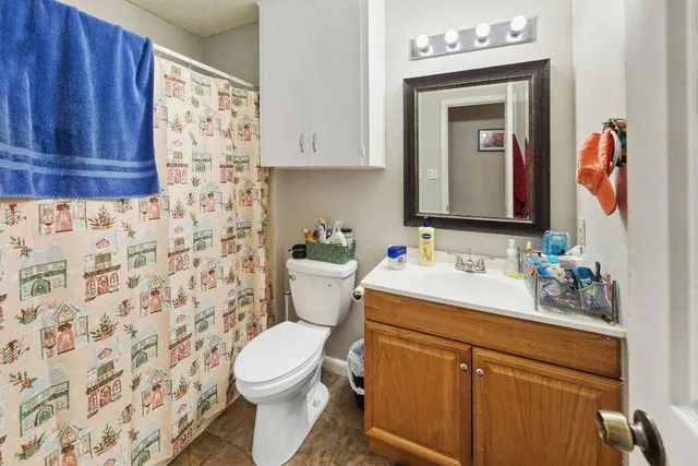 a bathroom with a sink vanity mirror and toilet