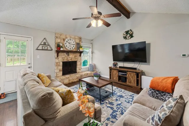a living room with furniture a flat screen tv and a fireplace