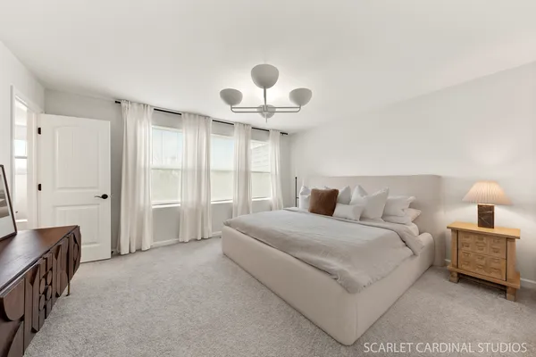 a spacious bedroom with a bed and a chandelier