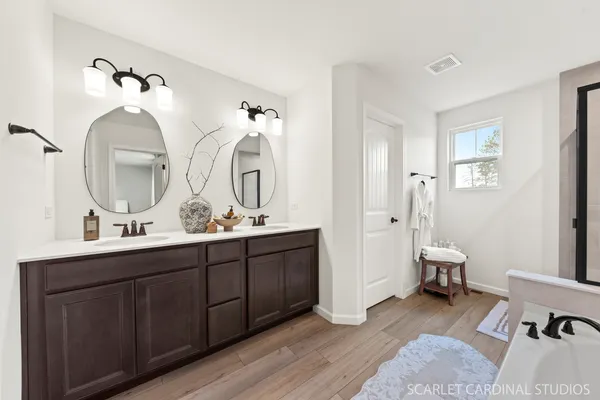 a en suite bathroom with a double vanity sink and a mirror