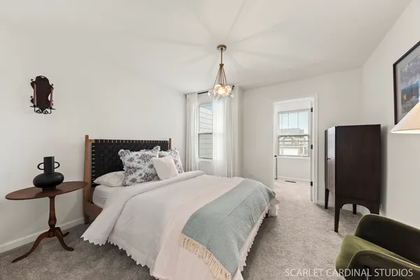 a bedroom with bed mirror and window