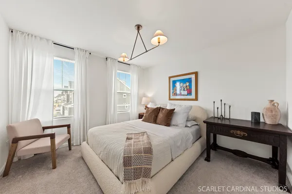 a bedroom with a bed and a table in it with window