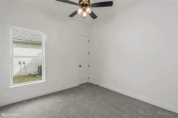 an empty room with a window and a fan