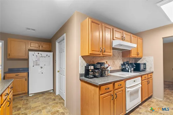 a kitchen with stainless steel appliances granite countertop a stove a refrigerator and cabinets