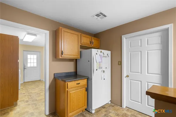 a view of walk in closet with window and refrigerator