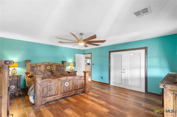 a bed room with a bed and a ceiling fan