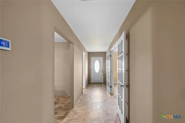 a view of a hallway with wooden shelves