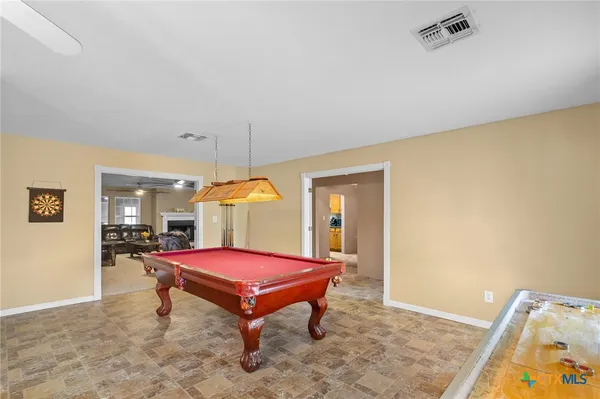 a room with pool table and windows