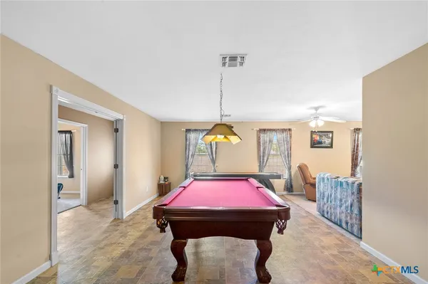 a room with furniture pool table and window