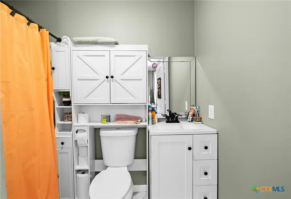 a bathroom with a toilet sink and mirror